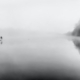 See im Nebel, in der Ferne ein Paddler